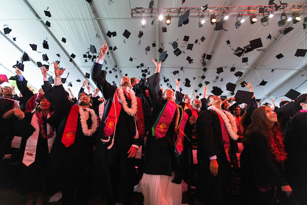 Class of 2025 throwing mortarboards into the air at CMC commencement ceremony